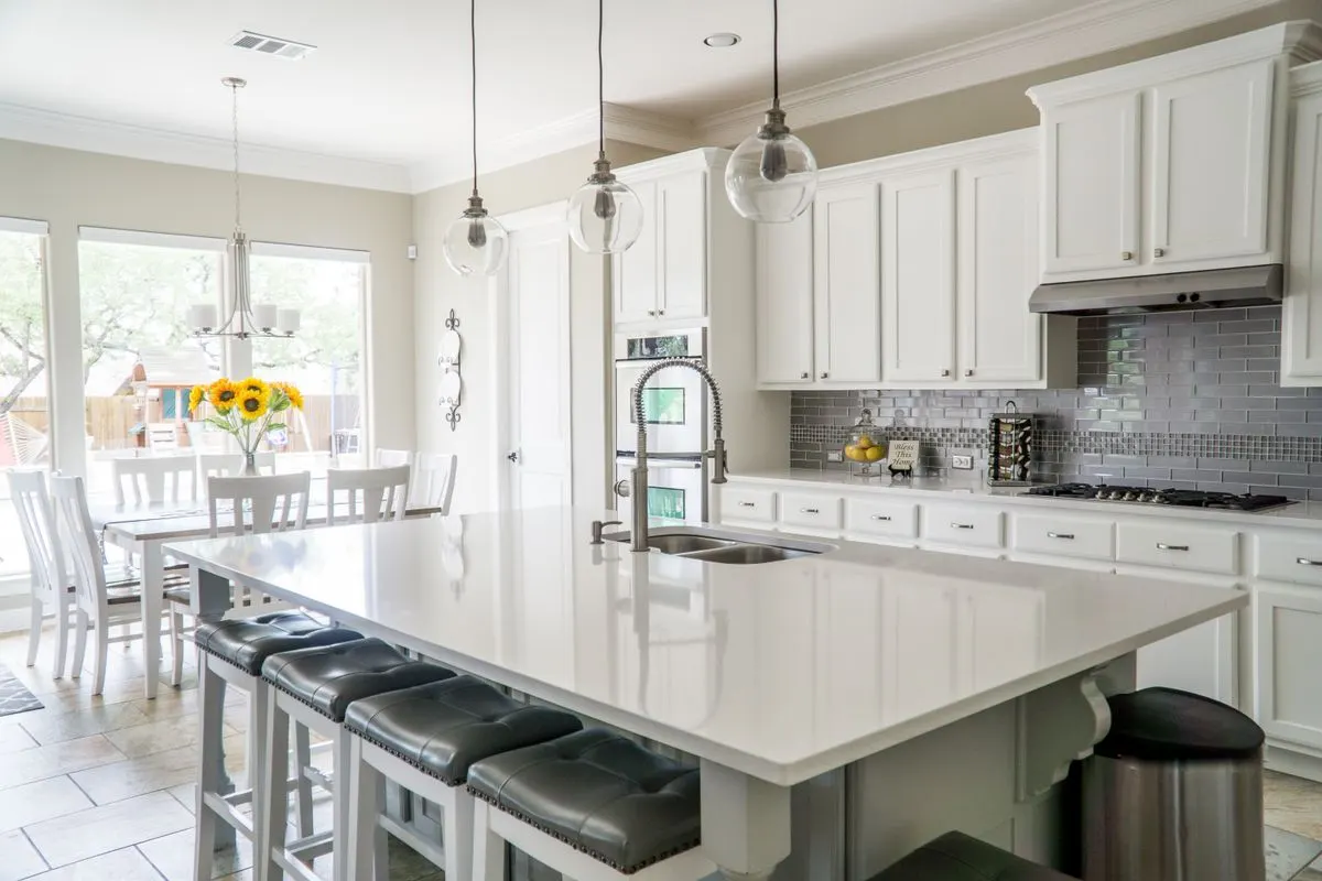 A bright white kitchen with clean counters and fresh sunflowers